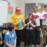 High School Heroes Hasan Baig and Jacob Cupps look on as sixth graders participate in an activity to demonstrate the harmful effects of marijuana.