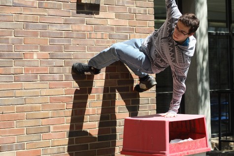 Sophomore Austin Valenti climbs a wall in the peace garden.