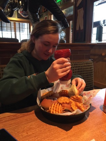 Diligently putting ketchup on her sliders, staff writer Emma Ratliff prepares to enjoy her meal.