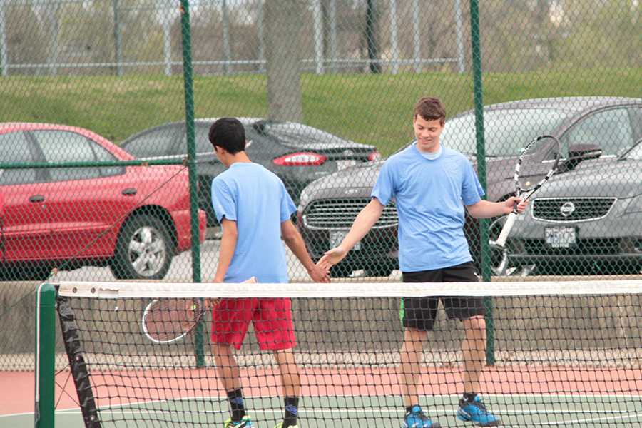 After winning a point, seniors Dillon Youngberg and Kenji Yanaba encourage each other as double partners.