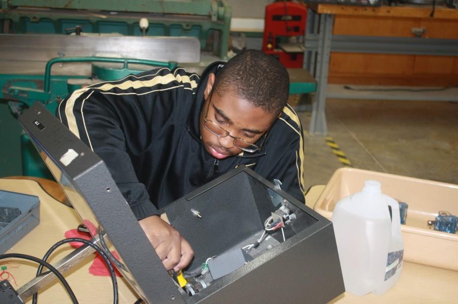 Junior Darrion Ward works on fixing an old projector to use the spare parts in the robotics class
