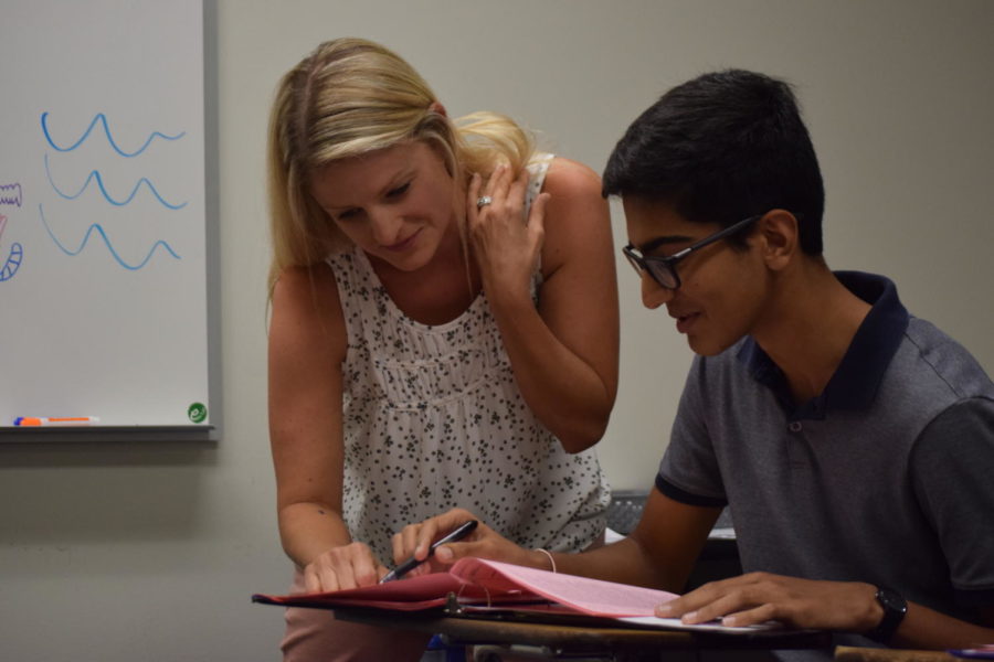 Helping junior Ronik Bhaskar with an assignment, English teacher Leslie Lindsey checks Bhaskars work on rhetorical analysis.  Bhaskar finds Lindsey attentive to her students needs. I think as a teacher, she is very structured and organized which is good, Bhaskar said. It helps makes sure everyone knows whats going on, whats going to happen and what they need to be prepared for. After setting up the kind of system, she still works hard to makes sure every student understands.