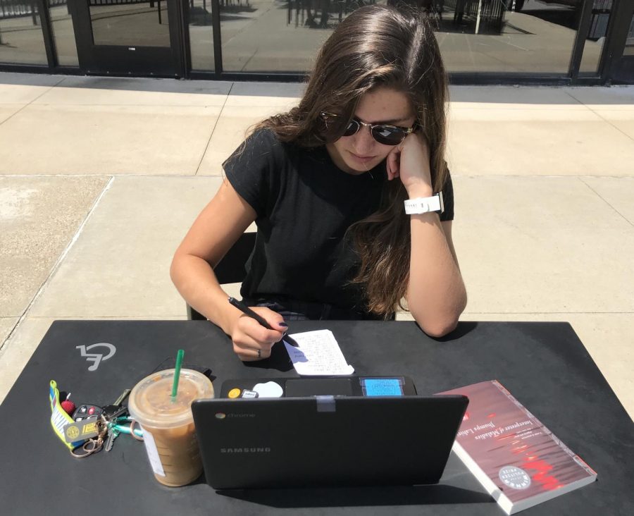 Senior Emma Caplinger studies a to-do list of summer assignments at the Town and Country Crossing Starbucks. Students have the entire summer to complete their homework, although most wait until the end of summer break. Having other people working around me makes me feel better about doing my homework during the summer, Caplinger said. Usually though, I just scroll through Instagram for a few hours and do it all the night before school starts.