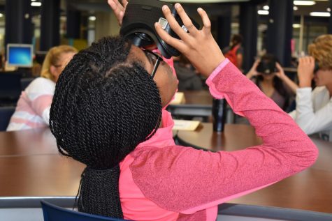 Looking into a virtual reality headset, sophomore Dyani May takes a virtual tour of the United States Holocaust Memorial Museum in her English II class Sept. 17. This was English teacher Casey Holland’s first time using VR in his classroom and was pleased with his students’ reaction to the tour. “It was different and exciting and fun,” Holland said. “The kids thought it was neat. When we started off, they were taking pictures of each other with their phones, but as the material we were talking about got more in depth, you could hear them saying ‘Oh wow,’ and hear them having some really good conversations with one another.”