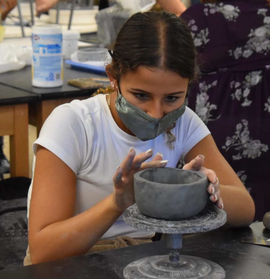 Sculpting+a+Day+of+the+Dead+project+in+Ceramics+1%2C+sophomore+Katie+Wallace+creates+a+mug+out+of+her+pinch+pot.+For+the+assignment%2C+Wallace+carved+eyes%2C+a+nose+and+a+mouth+into+her+mug%2C+and+later+painted+it+in+bright+colors+to+make+it+unique.+%E2%80%9CGetting+to+have+social+time%2C+unwind+and+talk+with+my+friends+was+my+%5Bfavorite+part+of+the%5D+class%2C%E2%80%9D+Wallace+said.+%E2%80%9CI+also+liked+getting+to+hone+my+creativity+and+get+my+hands+dirty.%E2%80%9D