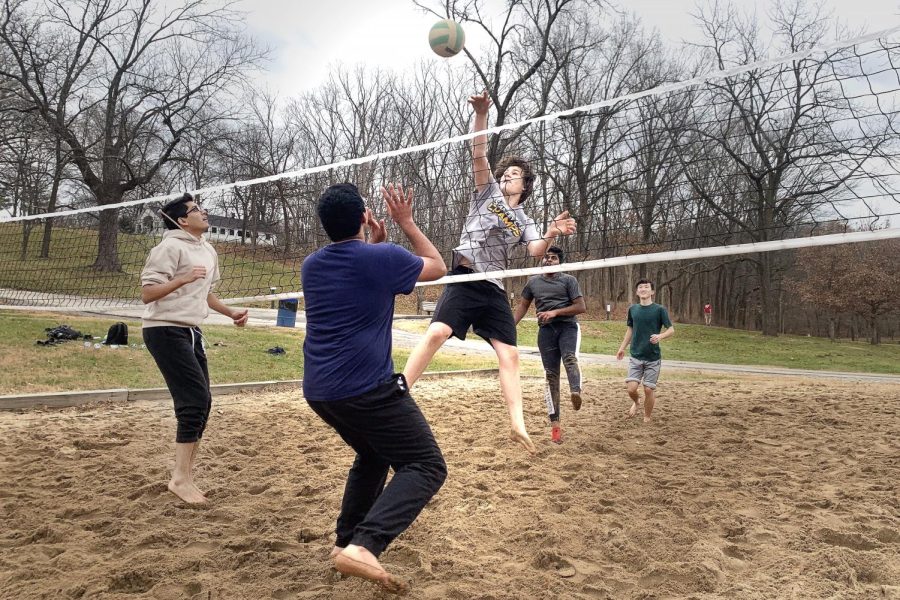 Digging+their+sandy+toes+into+the+ground%2C+seniors+Areeb+Hasan+and+Uzair+Mohsin+prepare+to+block+senior+Nathan+Meek%E2%80%99s+spike%2C+set+up+by+seniors+Manoah+Inje+and+Gordon+Yu.+The+boys+took+time+to+hype+each+other+up+after+plays.+%E2%80%9CTheres+a+lot+of+boosting+each+other+up.+As+you+play%2C+you+have+like+five+people+telling+you+how+great+you+are+and+that+feels+great.+When+we+get+off+%5Bthe+pit%5D%2C+people+always+comment+like+Oh%2C+so-and-so+has+gotten+so+good+at+this.%E2%80%99+I+love+that+we%E2%80%99re+learning+and+having+a+good+time%2C%E2%80%9D+Meek+said.