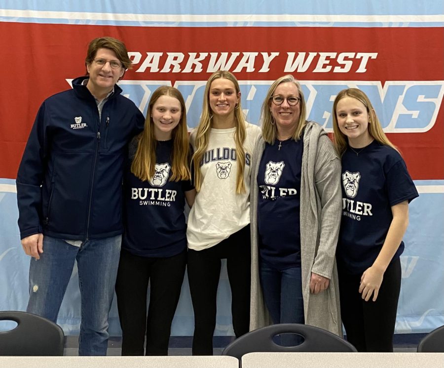 Posing in a picture with her family, senior Megan VanValkenburghsigns her National Letter of Intent to be a part of the swim and dive team at Butler University next fall. VanValkenburg committed and signed in December, but signing day at school occurred on February eighth. “All of the support from everyone on signing day made [committing] feel very real now. I feel like every little step I have taken in this process has led to that moment,” Vanvalkenburg said. “I have always loved the campus and location of the school, but [the girls on the womens swim and dive team at Butler] made me feel a part of their team on my visit, that’s when I knew I wanted to spend my next four years there.”