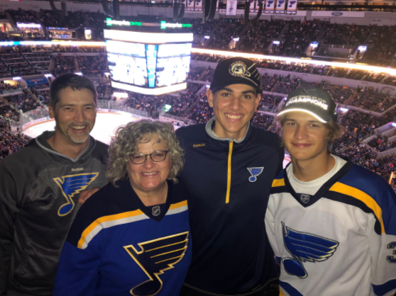 Senior Maxim Rinke (middle right) stands with his transfer family, the Harms, at a St. Louis Blues hockey game. As the months roll by, the Harms’ have found that he fits into their family naturally. “I think it was a little bit awkward at first but as time goes by, he is fitting in really well, and now he feels just like my real brother,” junior Mitchell Harms said.