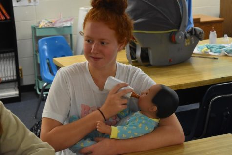 Practicing child care, sophomore Ava Sticht feeds an electronic baby in Child Development class. Students practiced swaddling, feeding, burping, rocking and buckling the babies into car seats. “Everything was going good until the baby just randomly screamed at me. Normally they scream if you don’t support their head, but I was, so it took me by surprise,” Sticht said.
“I really loved kids and can’t wait to take the baby home for the weekend.”