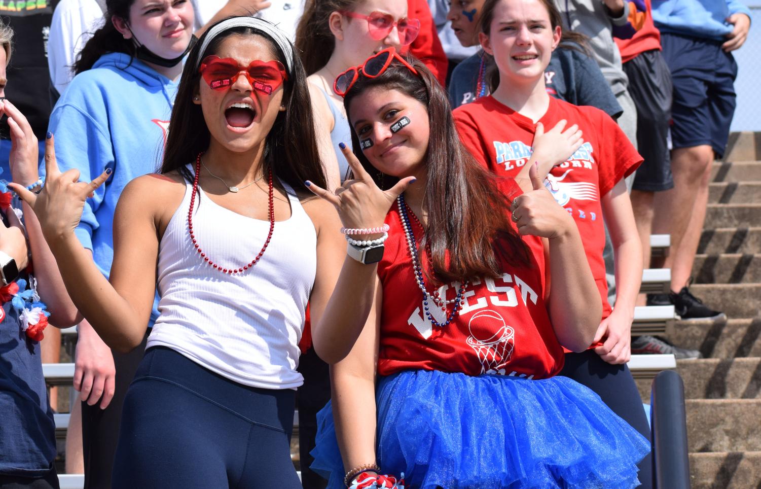 Celebrating the 2021 Fall Pep Assembly, seniors Esha Franics and Maya Malhorta dress in spirit colors red, white and blue. The duo worked on planning the Homecoming assembly, parade and Powder Puff game. “Im more in charge of the parade and the floats. Esha is more in charge of the pep assembly and Powder Puff,” senior Maya Malhorta said. “There’s a lot of things to do behind the scenes, especially picking [main] theme and planning all of the spirit day themes, but it is a lot of fun. I picked disco [for the class theme] because I think it would be the most fun. I am disappointed the teachers didn’t get rock; I was hoping they would.” 