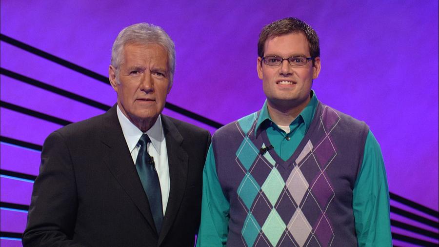 Filming his hometown howdy, math teacher Patrick Mooney stands next to Jeopardy host Alex Trebek. “Alex is great. He is really smart and funny and he even wants to get a picture with every single contestant,” Mooney said. 