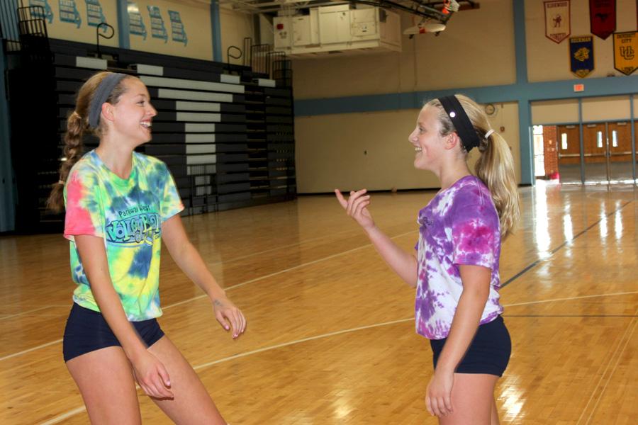 Practicing before the Red and Blue Night scrimmage, freshmen Molly Thomas and Grace Folkins talk in the main gym on Aug. 23. The volleyball team has participated in practice, scrimmages, and Sister Saturday, where they played sand volleyball and tie-dyed t-shirts. “I’m excited about becoming closer with my teammates this season because they are all really nice and we have had a lot of fun so far,” Thomas said.

