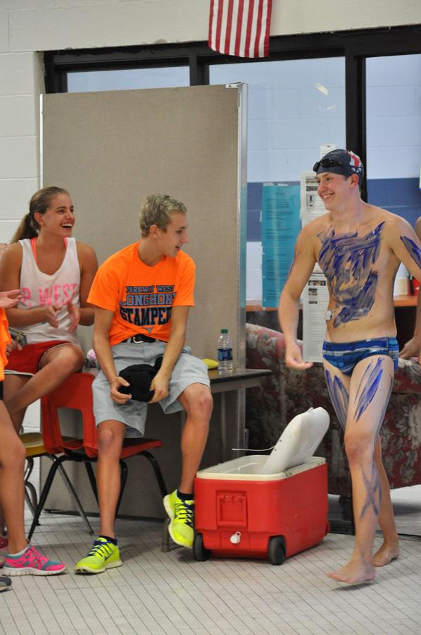 Warming up for Red and Blue night on Aug. 23, senior Eli Harris is painted blue. Harris was put on the blue team for the fourth year in a row. Harris’ teammate junior Noah Bozue splattered him with blue paint before his race. “Even though we made a huge mess in the swim office, and the paint came right off after I jumped into the pool, it was so worth it,” Harris said.