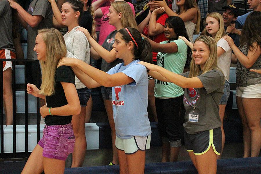 Freshmen Claire Goedde, Caroline Shaw and junior Rachel Ebner give each other back massages as part of New Student Orientation.