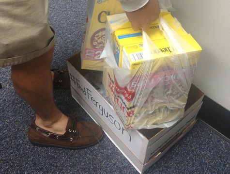 Bobby Connor delivers donations of Cheerios and canned chicken into a grade level office for the Help Heal Ferguson food drive.