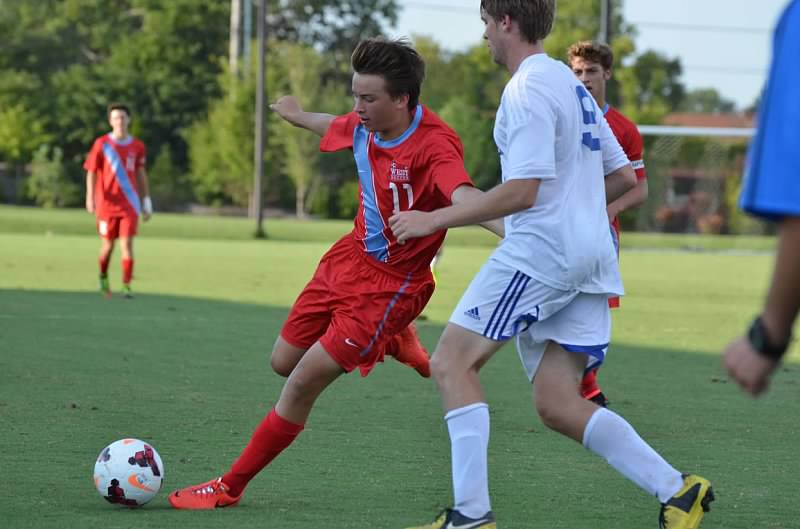 Playing in the varsity game against Westminster, freshman Jack Galkowski shoots the ball towards the goal.