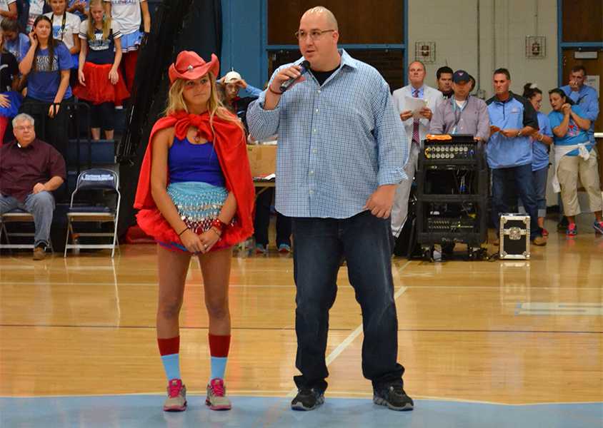 Junior Mary Galkowski and Sergeant Joshua Eckhoff  walk into the middle of the gym during the fall pep rally. 