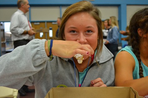 Biting into a lemon bar, Junior Julia Patterson enjoys the food and her friends at  Taste of West. I love going to Taste of West. I look forward to it every year, said Patterson. 