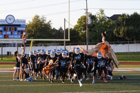 Before the third home game, against Rockwood Summit, senior Abryon Givins rips through the banner the varsity cheerleaders made. “Home games were great because we had our school cheering for us and we wanted to win for our home team.  At away games we did not have that kind of support,” Givins said.