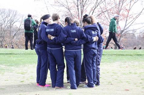 Huddling before the race, the girls cross country team chants Carpe diem, lets go West!