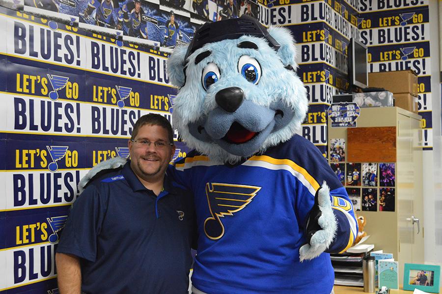 Gerry Wieczorek stands with  the Blues mascot Louie the Bear.