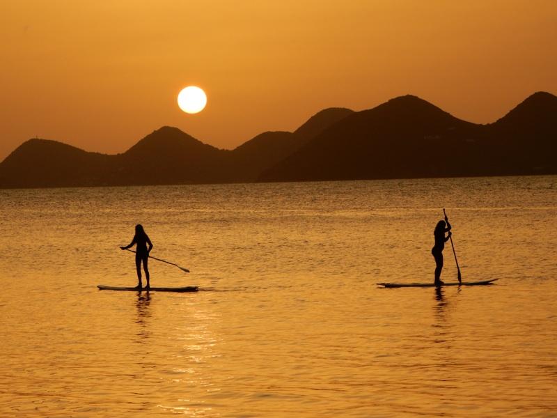On the British Virgin Islands, junior Megan Barton and Corinne Schillizzi paddle board.