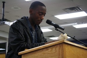 During the 13th annual African American Read-In in the West High library, junior Donte Hopkins reads “Love Your Enemy” by Yusef Iman.  Pizza and dessert was served to all student present. “We all have to live together.  In the past there was so much hatred.  The poem is telling everyone not to forgive them for everything they have done, but instead love them.  It represented how we have to keep moving forward and love each other no matter what happens,” Hopkins said.