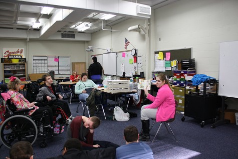 Students circle around as junior Sarah Goldblum reads The Berenstain Bears.