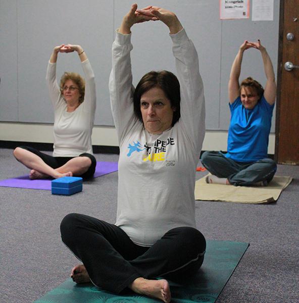 Technology specialist Pam Van Mater in the shoulder stretch position, meant to release tension in the neck and shoulders.