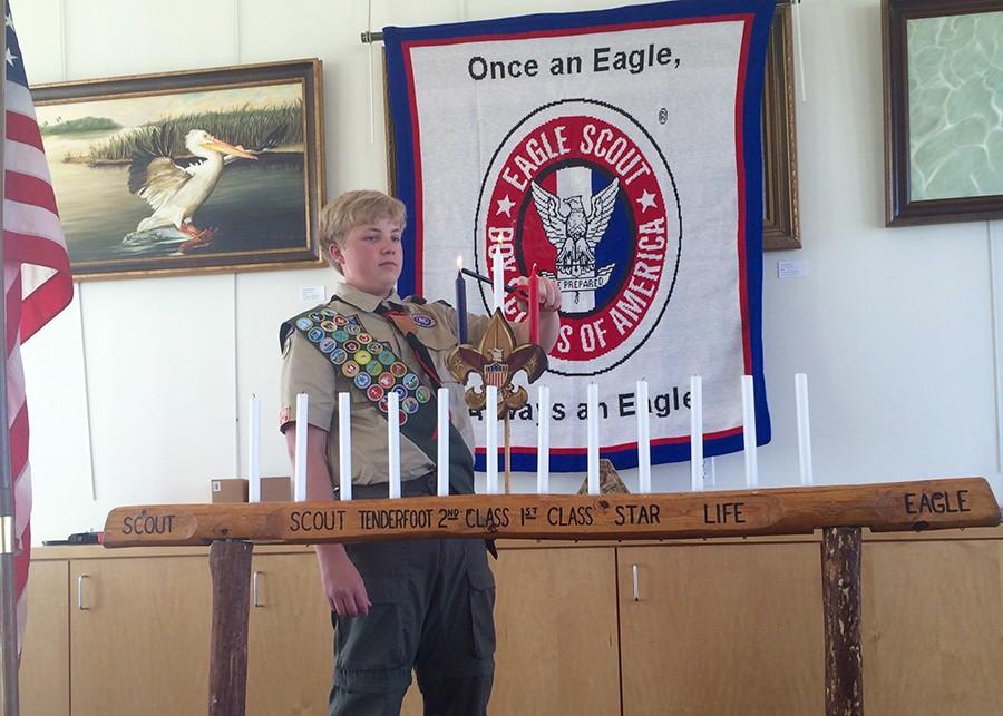 Christopher Narishkin lights the red, white and blue candles to symbolize what he will do to honor his expectations as an Eagle Scout. 