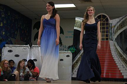 Sophomores McKenzie Land and Claire Pellegrino walk down the runway at the annual Prom Fashion Show. Models selected dresses to borrow from Camille de la Vie for the show, and beauty school students did the models hair and makeup. For people that are shy, I would suggest them doing it because its really fun, Land said. You have fun with your friends and get out there and strut your stuff.