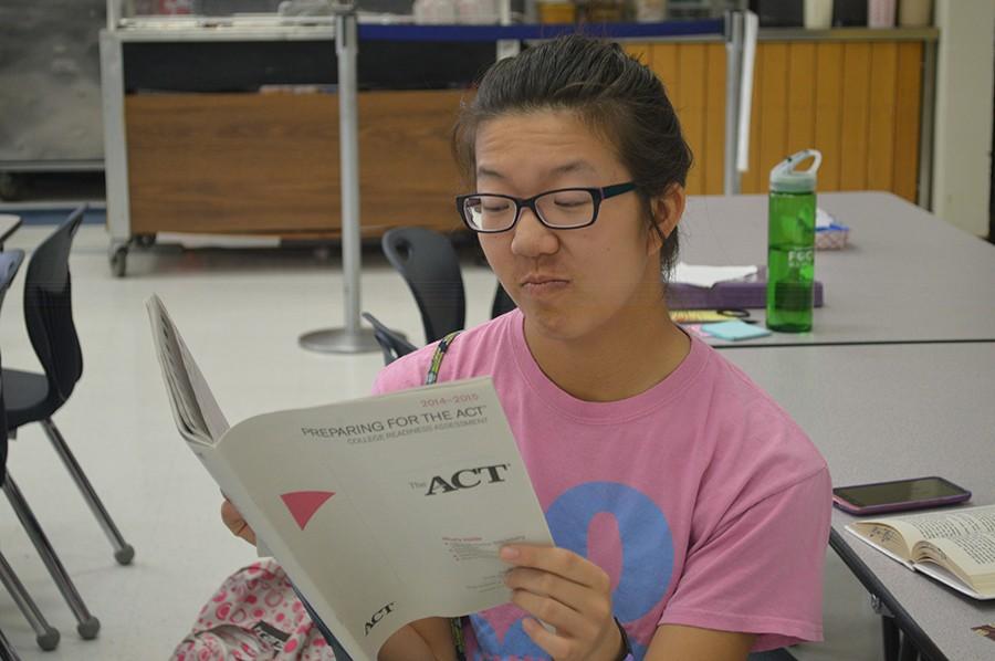 Junior Rebecca Su frowns at the familiar ACT preparatory book that students used to study for the test. This year, Ms. Witt offered a preparation course that provided these booklets to students wishing to get ahead of the game.  