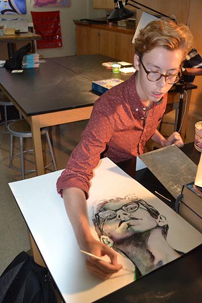 Knabe works on an abstract self portrait in AP Art Studio. 