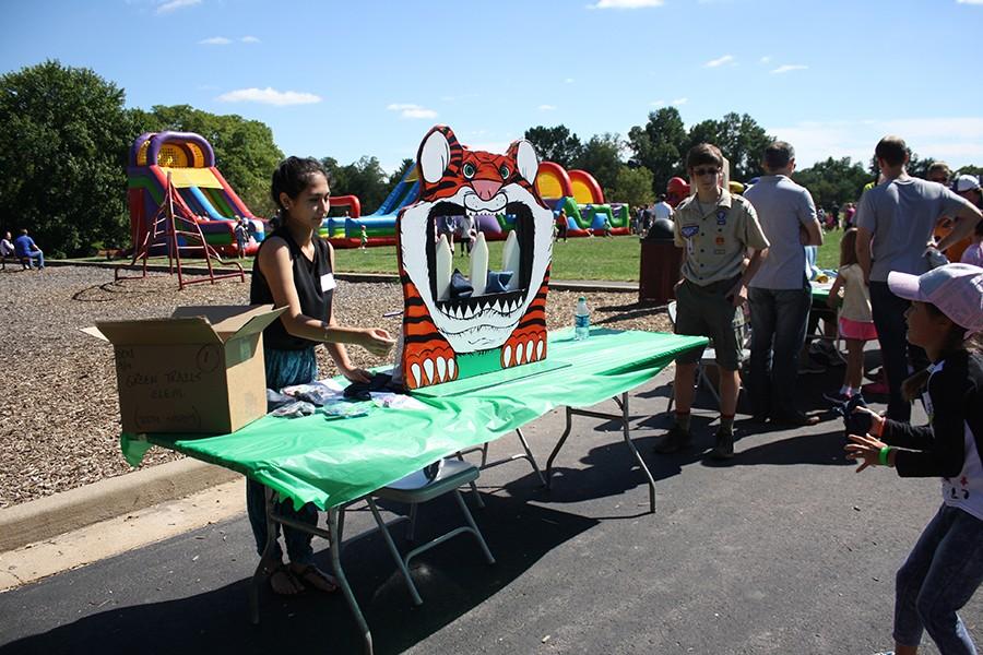 Volunteering at the Green Trails fall carnival, sophomore Sarah Habibollah tosses a bean bag to an elementary student.  