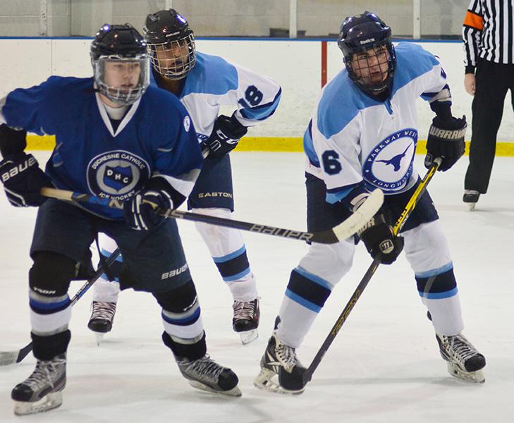 Facing off, senior Trevor Shockley from Duchesne, fights to get the puck from seniors Hasan Baig and Jacob Ransom.