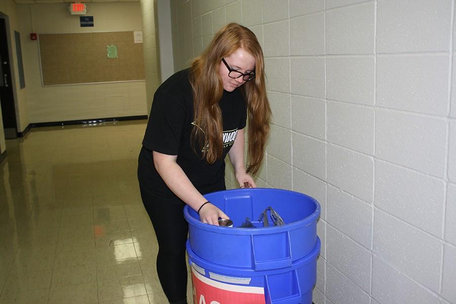 Sorting through the can food drive bin, junior Mallory Garrett removes cans from bags.