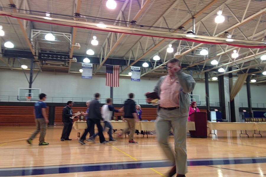Math teacher Patrick Mooney rushes results and awards to the students after the test.