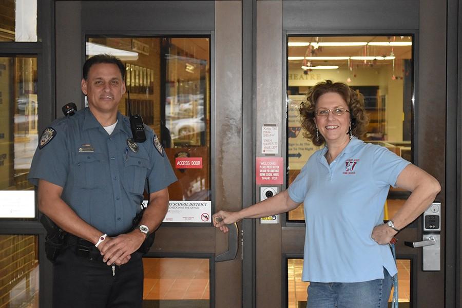 School Resource Officer Scott Scoggins and Front Office Receptionist Vickie Hankammer stand outside the access door.