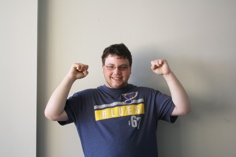 Wearing Blues apparel to show support for his favorite hockey team, junior Tyler Hannegan poses excitedly.