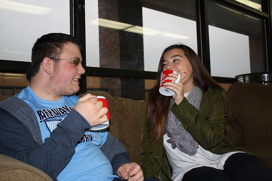 Junior Tyler Hannegan and Senior Ally Guccione sit on a couch and enjoy the popular holiday drink, peppermint hot chocolate.