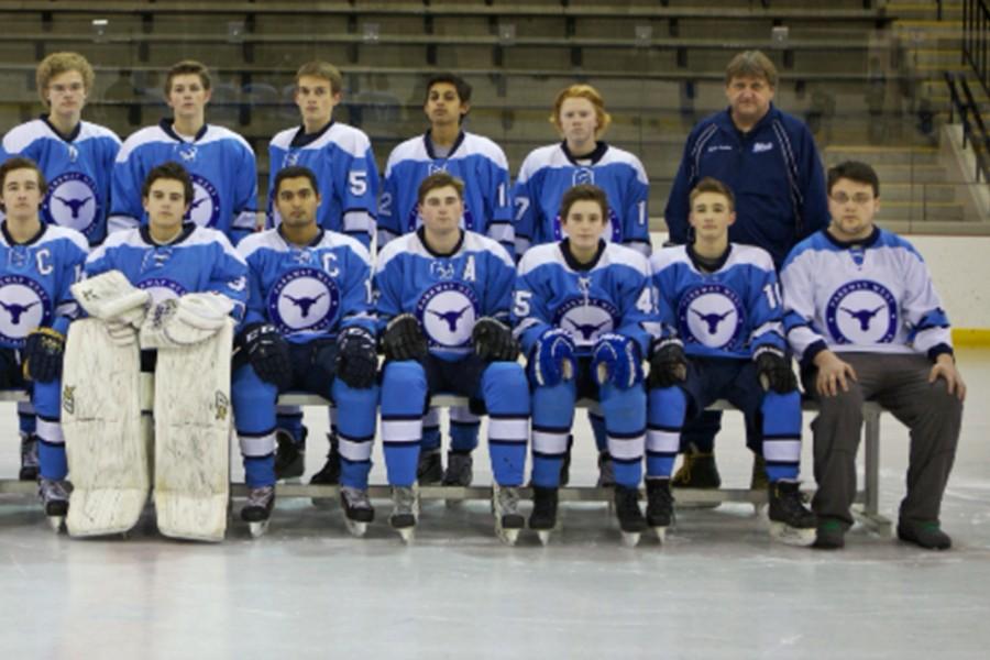 Posing+for+the+team+picture%2C+Tyler+Hannegan+sits+with+the+rest+of+the+varsity+hockey+team.