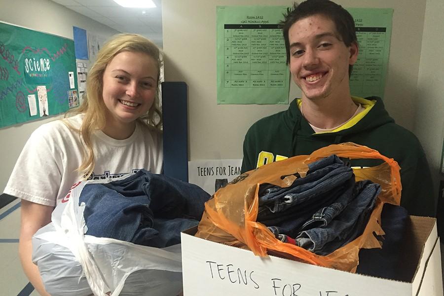 Seniors Grace Goedde and Tommy Stimac help move donated jeans.