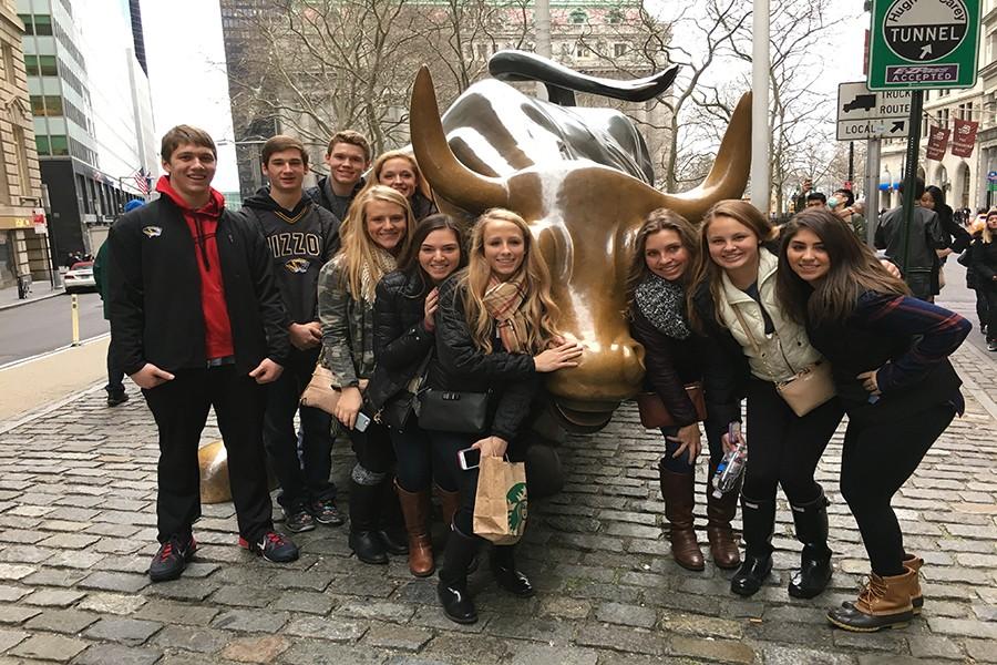 Marketing students pose by the bull on Wall Street.