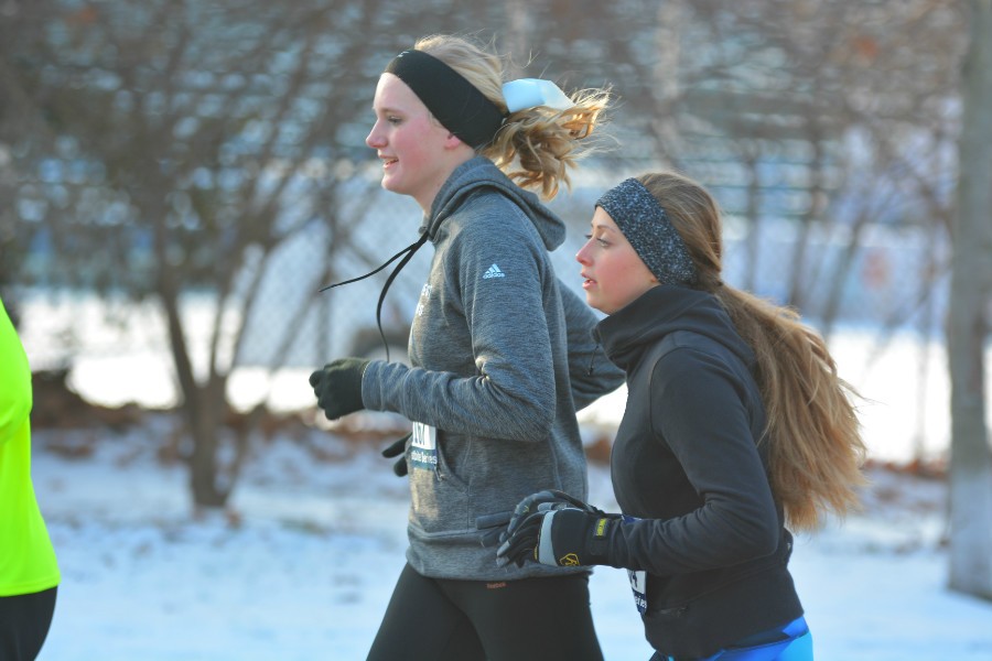 Butler and Osborne run together before the eighth mile-marker, Osborne sporting West's blue cross country bow. With temperatures skimming 32 degrees, both runners wore headbands to guard their ears from the wind.