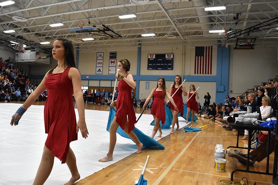 Dressed in red, Winter Guard parades across the gym with their flags in hand. The winter guard performed their dance to the song “Boom Clap”. “My favorite dance move is the pop toss which is when we all throw our flags up at the same time. It was one of the big ensemble moments of the performance,” freshman Deirdre Jost said. Winter Guard has competed in four competitions so far. 
