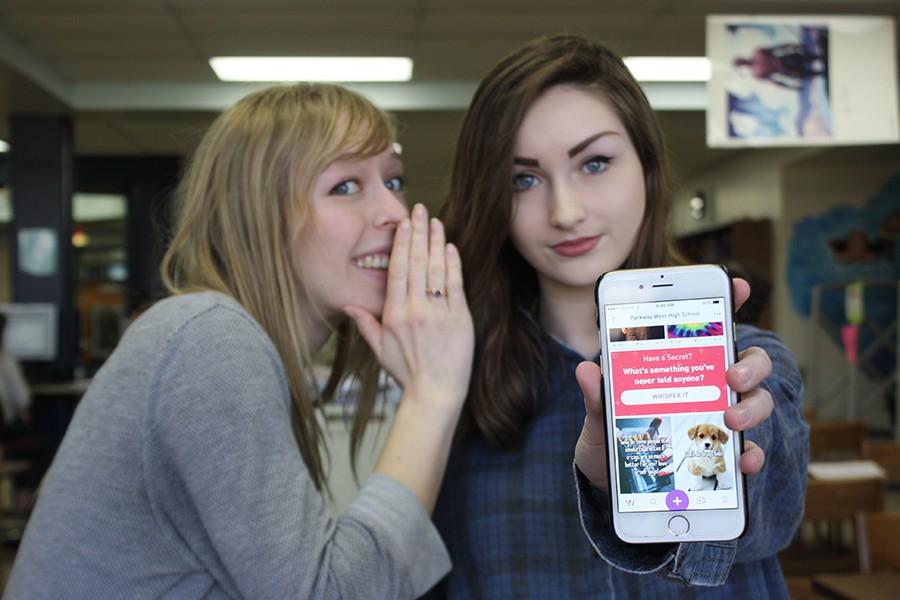 Senior Abby Larsen and sophomore Kennedy Brown pose in the library with the app, Whisper. The app has over 87 users from West so far.  “I think most of the time when people first hear about it they think it’s mostly for negative things because that’s how most anonymous apps work. But on Whisper, there is a place for just our school. That’s where I am most of the time. Everywhere else, there are mean comments, but mostly at our school it’s just positive things,” Brown said.