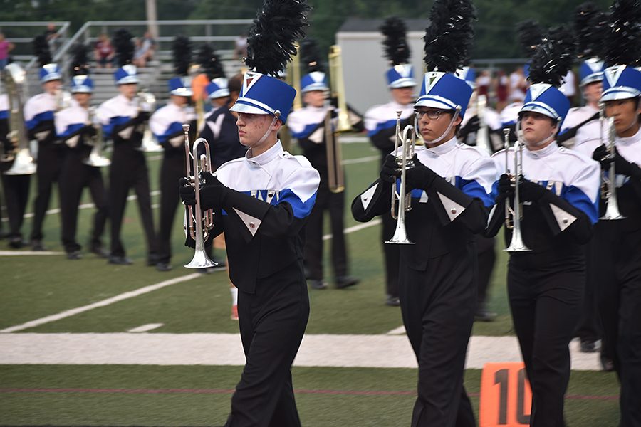 The marching band clears the field after they form a tunnel for the varsity football team at the game on Aug. 26. They performed the first movement of their competition show, "Journey Through the Night," at halftime later that night.