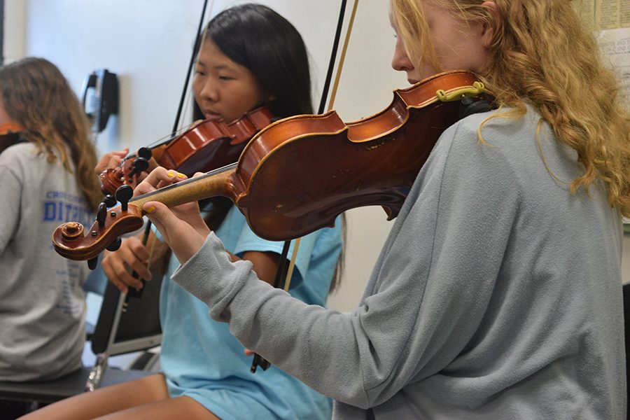 Juniors Sydnee Yap and Emma Richards rehearse in the first violin section of the Symphonic Orchestra.