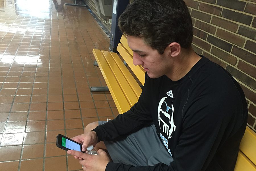 Senior Drew Seers checks his fantasy football roster during school.