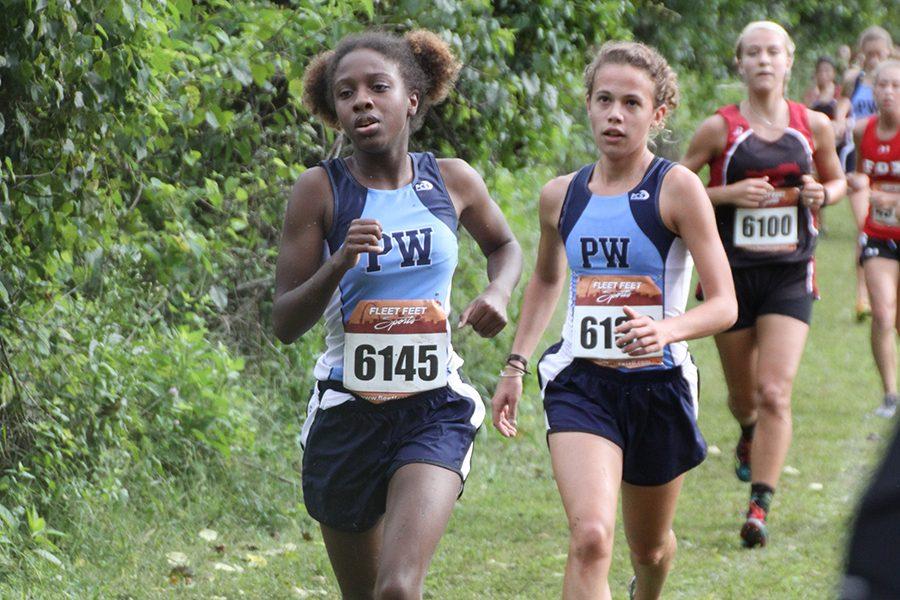 Racing+ahead%2C+varsity+runners+and+seniors+Rikita+Saunders+and+Maggie+Morse+compete+at+the+Stan+Nelson+Invitational.+